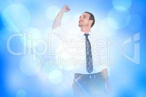 Composite image of businessman cheering with clenched fist