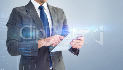 Composite image of businessman using his tablet pc