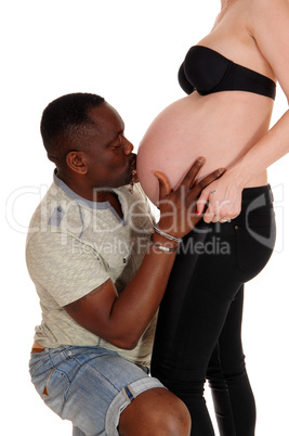 Black man kissing baby belly.