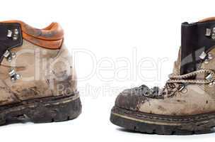 Old dirty hiking boots on white background