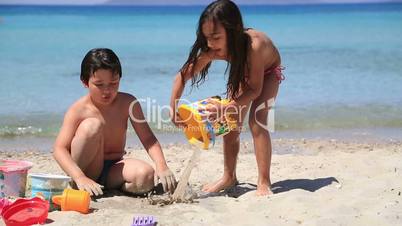 little boy and girl playing on beach