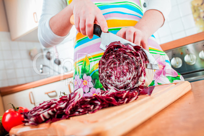 Woman's hands cutting red cabbage