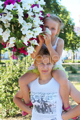 daughter sitting on her mother and many flowers