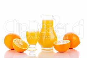 Orange juice in pitcher and oranges