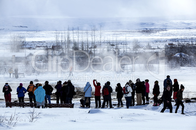 Visitors watching the eruption of a geyser in Iceland