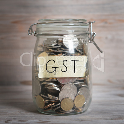 Coins in money jar with gst labe