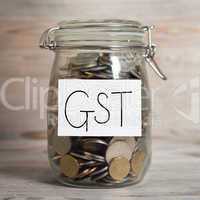 Coins in glass money jar with gst label