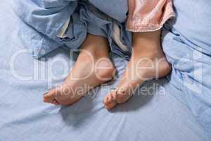 Bare Feet of a Young Woman on Blue Bed