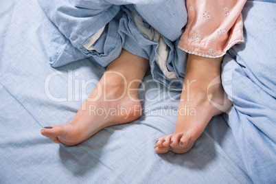 Bare Feet of a Young Woman on Blue Bed