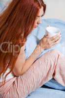 Pensive Woman Having an Early Coffee at her Bed