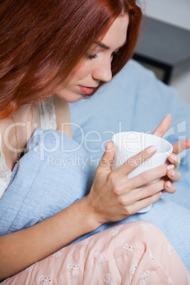 Pensive Woman Having an Early Coffee at her Bed