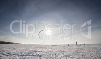 Kiteboarder with blue kite on the snow