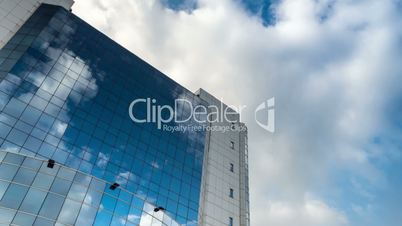 sky with clouds reflected in a modern office glass building
