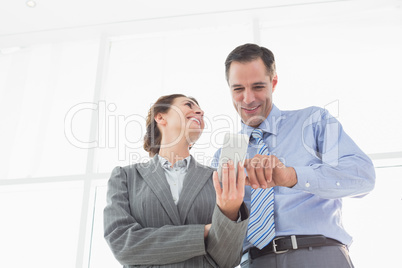 Businesswoman showing something to her colleague on her smartpho