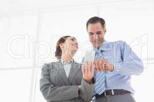 Businesswoman showing something to her colleague on her smartpho