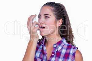 Pretty brunette woman using asthma inhaler