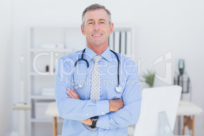 Smiling doctor looking at camera with arms crossed