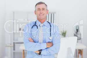 Smiling doctor looking at camera with arms crossed