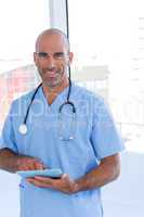 Smiling doctor using tablet computer