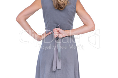 Wear view of woman hiding knife behind her back