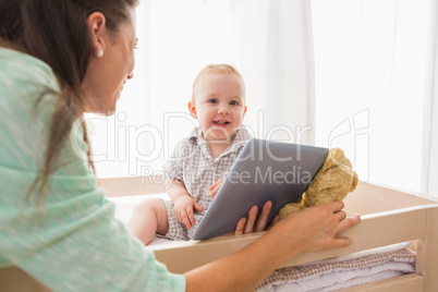 Happy mother using tablet with his baby boy