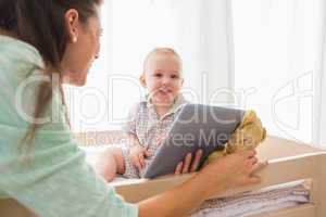Happy mother using tablet with his baby boy
