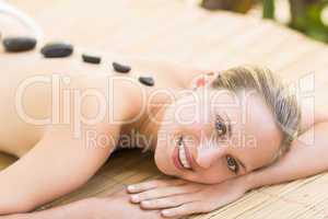 Beautiful woman receiving stone massage at spa center