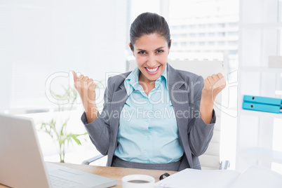 Happy businesswoman with raised arms