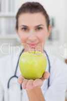 Smiling doctor showing apple