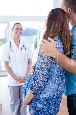Smiling obstetrician and happy couple