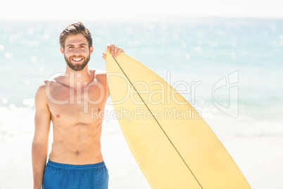 Handsome man holding surfboard