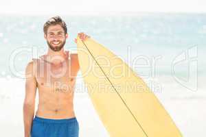 Handsome man holding surfboard