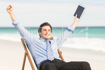 Businessman cheering on the beach