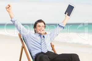 Businessman cheering on the beach