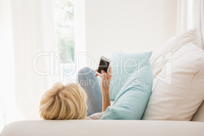 Smiling blonde woman using her mobile Smiling blonde woman using her mobile