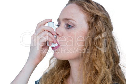 Pretty blonde using an asthma inhaler