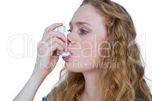 Pretty blonde using an asthma inhaler