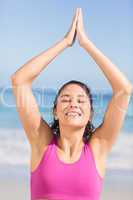 Fit woman doing yoga beside the sea