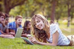 Pretty blonde using tablet in the park