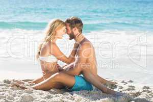 Happy couple relaxing together in the sand