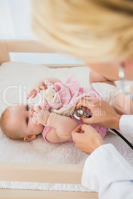 Beautiful cute baby girl with doctor with stethoscope