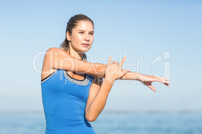 Beautiful fit woman stretching her arm