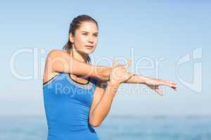 Beautiful fit woman stretching her arm