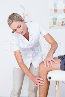 Doctor examining her patient knee