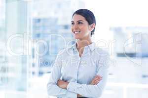 Beautiful businesswoman with arms crossed at office