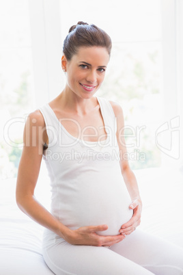 Happy pregnancy sitting on the bed