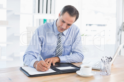 Businessman writing on a paper