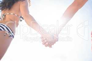 Rear view of couple holding hands at the beach