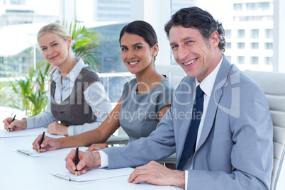 Smiling group of business people taking notes