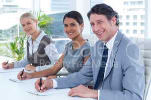 Smiling group of business people taking notes